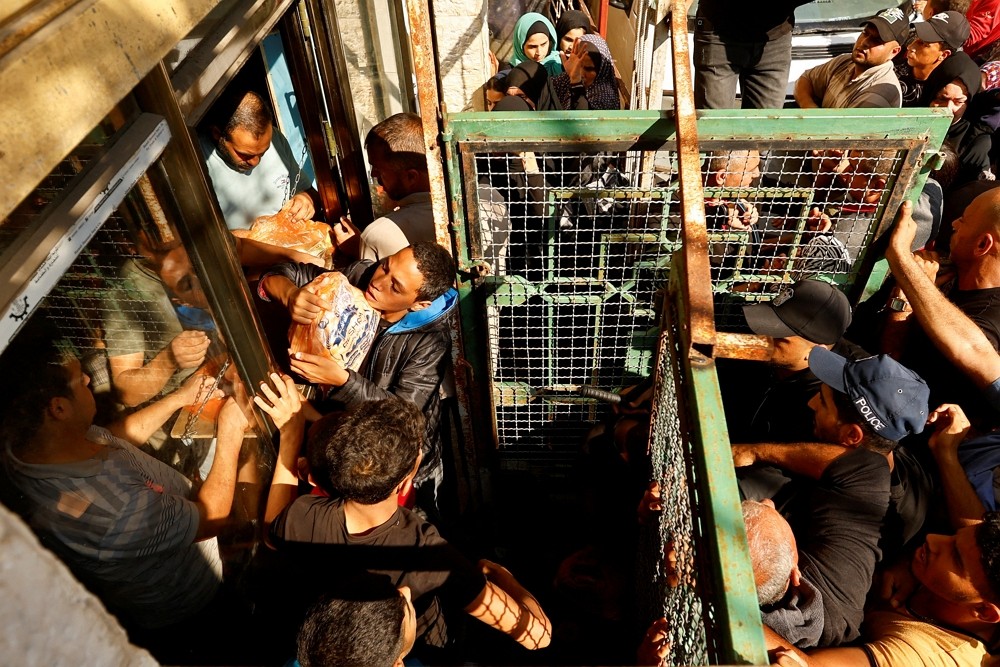 Palestinians queuing to buy food.