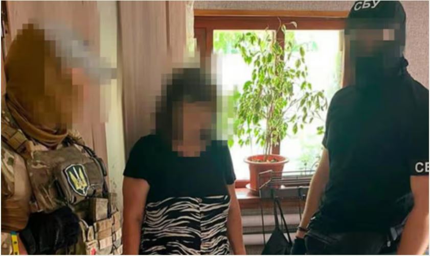The SBU security service published a blurred image of the woman being detained by masked officers in a kitchen. (SBU)