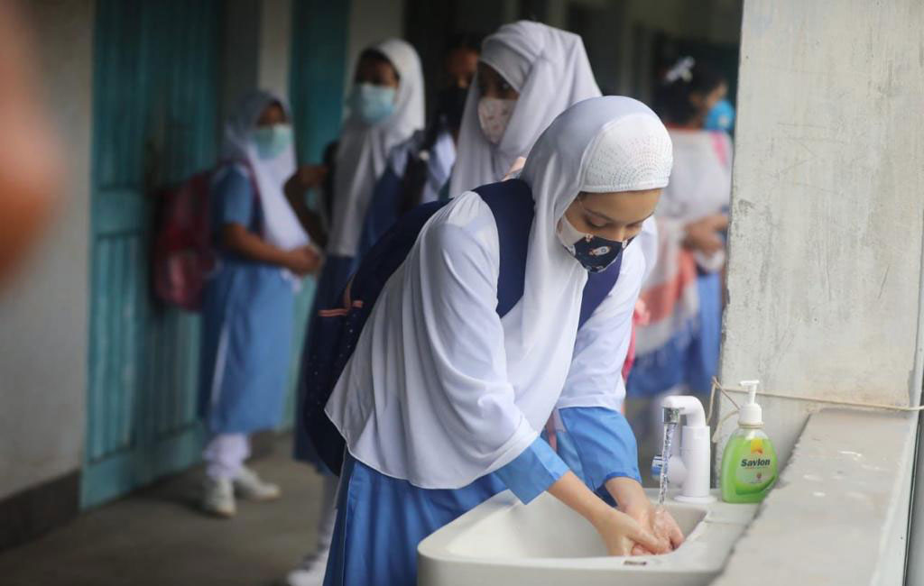 A student washing hand before entering a school in Dhaka on Sunday, September 12. Photo: Dhaka Tribune.