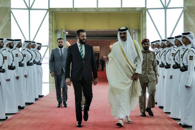 Interim President Ahmed Al-Sharaa, left, is received by Qatar’s Emir Sheikh Tamim bin Hamad Al-Thani at Hamad International Airport in Doha on April 15, 2025. (Syrian Presidency/AFP)