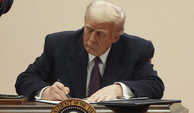 President Donald Trump signs executive orders an indoor Presidential Inauguration parade event in Washington, Monday, Jan. 20, 2025. (AP)