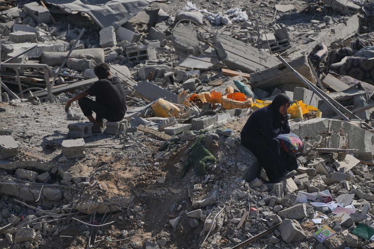 A displaced Palestinian woman sits amid rubble in Gaza City’s Sheikh Radwan neighborhood after the Israel-Hamas ceasefire. | Photo: AP