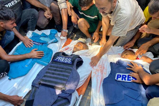 Mourners gather over the bodies of journalists Moaz Abu Taha, Hussam Al-Masri, and Mohamed Salama, killed in an Israeli strike on Nasser Hospital, Khan Younis, Gaza, Aug. 25, 2025. (AFP)