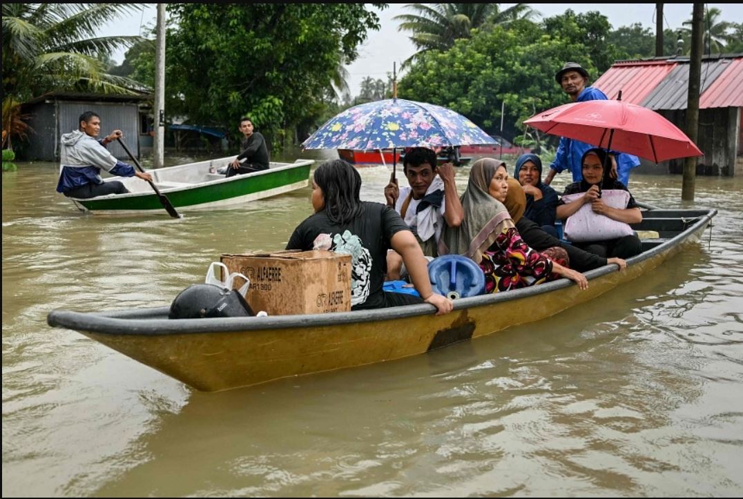Residents moving through flood waters on boats in Kelantan, Malaysia, on Nov 30. PHOTO: AFP