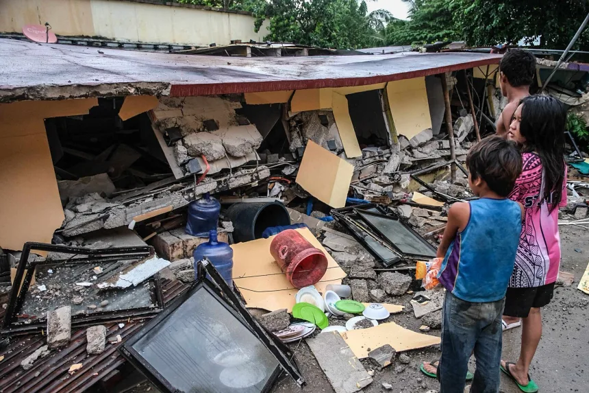 People look at a collapsed building in Bogo City, Cebu, Philippines, on Wednesday, October 1, 2025 after an offshore earthquake on late Tuesday. AP