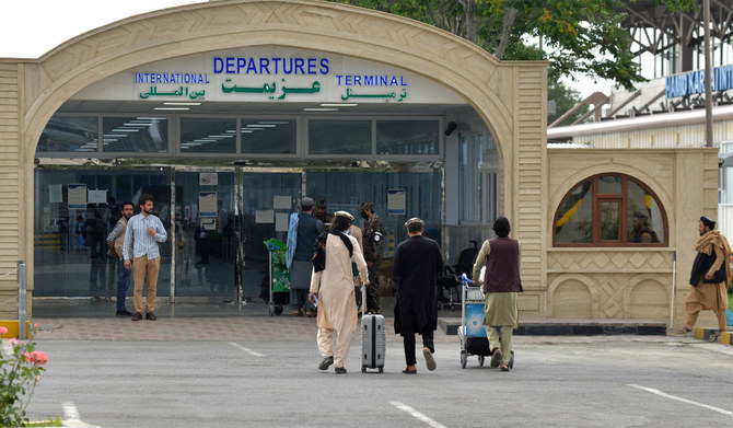 Passengers with their belongings walk towards the entrance gate of the airport in Kabul. (AFP file photo)