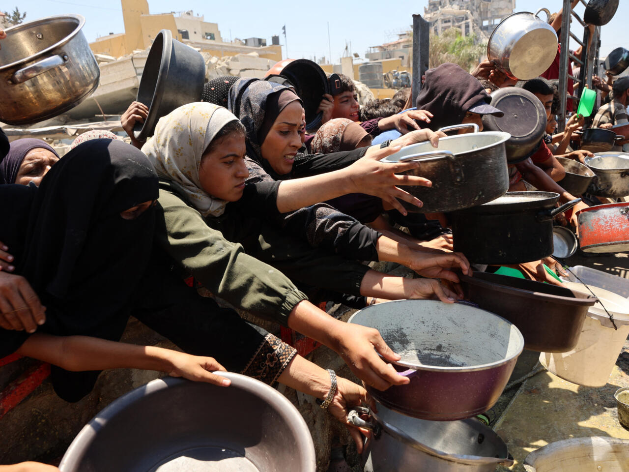 Palestinians receive lentil soup at a food distribution point in Gaza City on August 2, 2025-- Photo: Omar Al-Qattaa, AFP