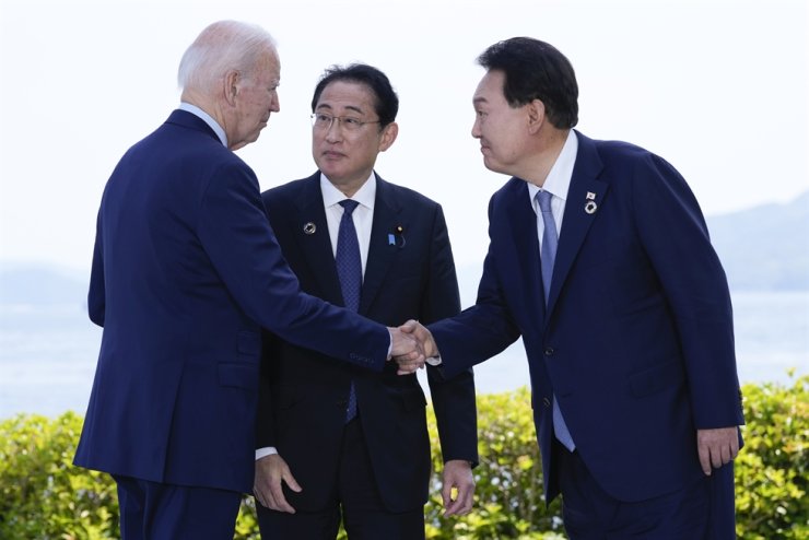 President Yoon Suk Yeol shakes hands with U.S. President Joe Biden as Japan's Prime Minister Fumio Kishida watches on. Hiroshima, May 21. Photo: AP