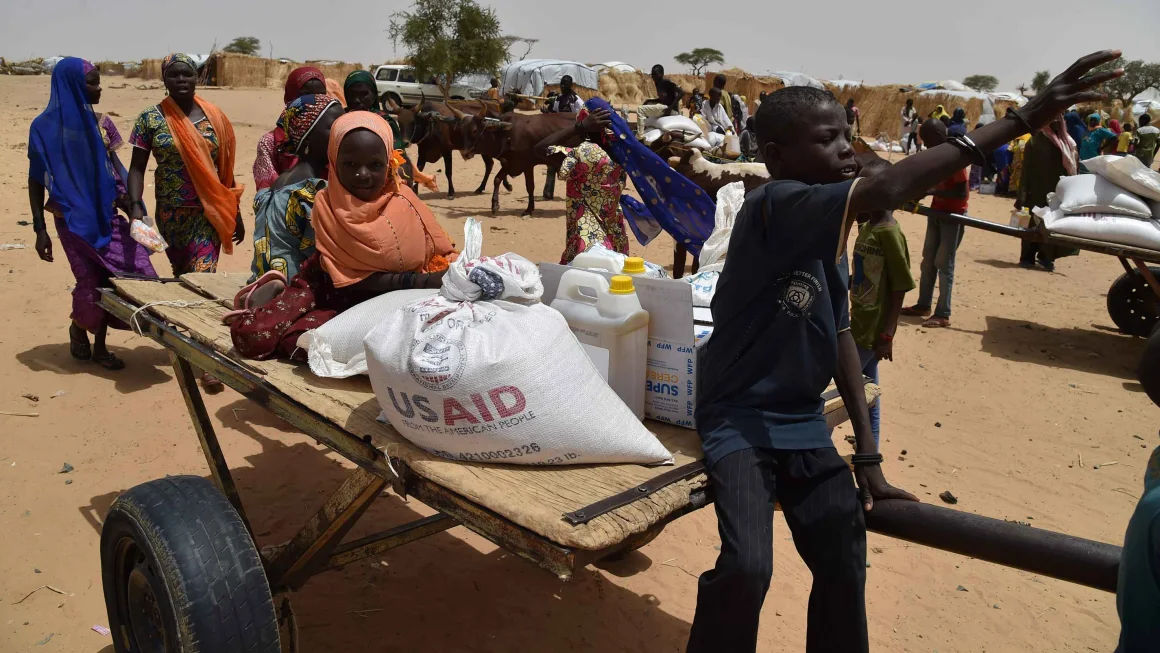 Displaced people fleeing from Boko Haram incursions into Niger attend a World Food Programme (WFP) and USAID food distribution on June 16, 2016. ISSOUF SANOGO/AFP/Getty Images