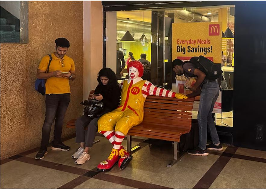 A person sits outside a McDonald's restaurant in Mumbai, India, February 26, 2024. REUTERS/Francis Mascarenhas/File Photo.