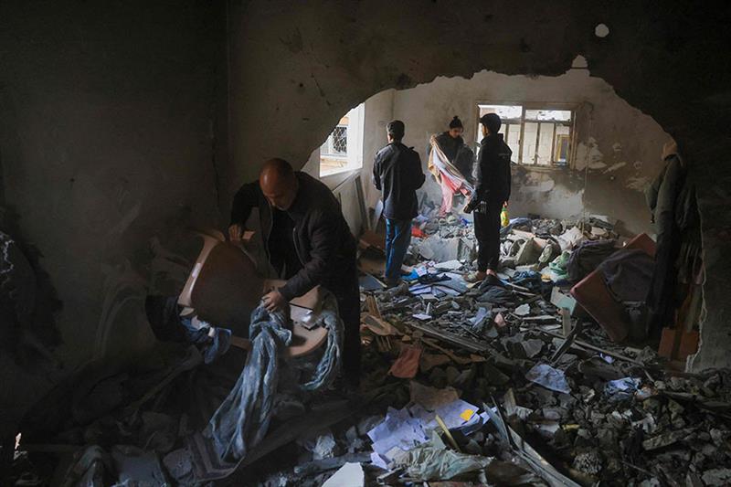 Palestinians salvage items from a house after an Israeli military attack: AFP