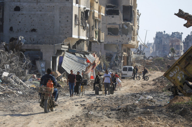 Palestinians walk through the destruction left by the Israeli air and ground offensive after they withdrew from Khan Younis. (Alamy Stock Photo)