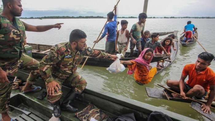 Soldiers provide food aid to the affected families in flooded residential areas following heavy monsoon rainfalls in Goyainghat, Bangladesh.