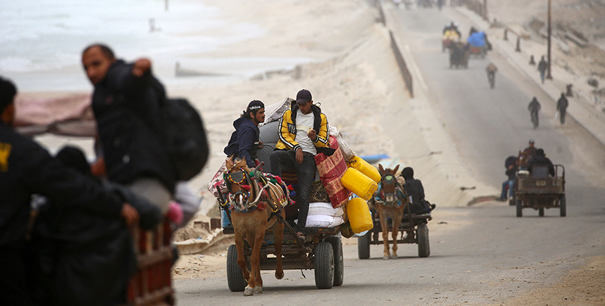 Palestinians ride vehicles with their belongings as they flee from the northern Gaza Strip toward the south, via the Salah al-Din road near the Nusseirat refugee camp on Thursday. (AFP photo)