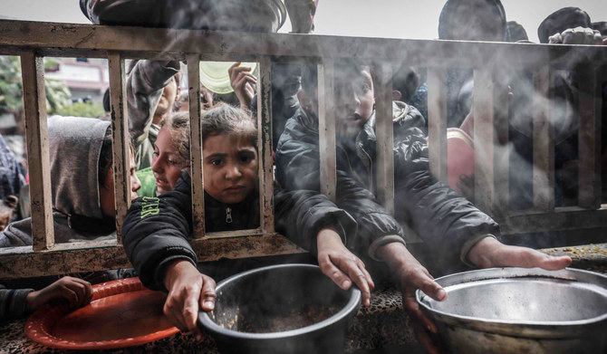 Displaced Palestinian children gather to receive food at a government school in Rafah in the southern Gaza Strip on February 19, 2024. (AFP)